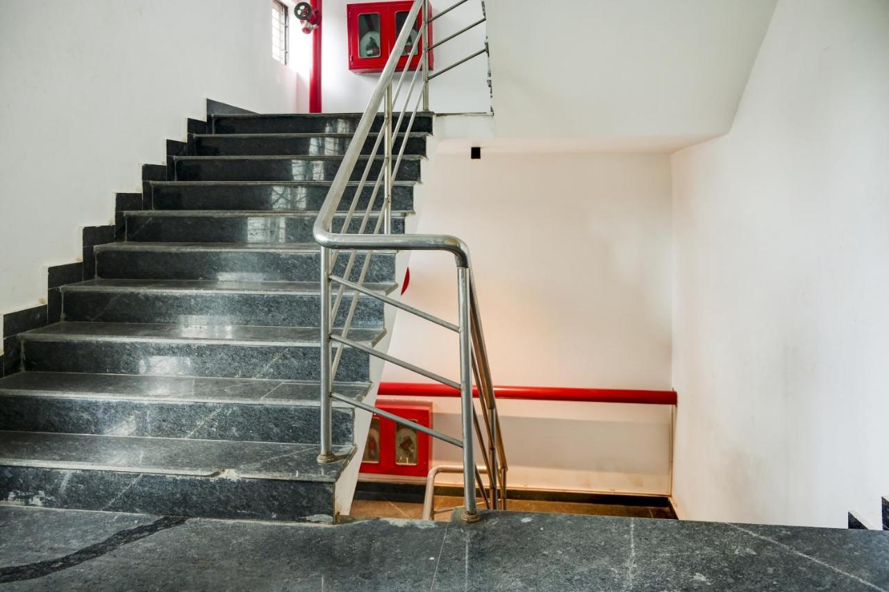 Gray marble staircase with stainless steel railing ascends at pet-friendly Town House HI5 Aditya International in Bhubaneshwar.