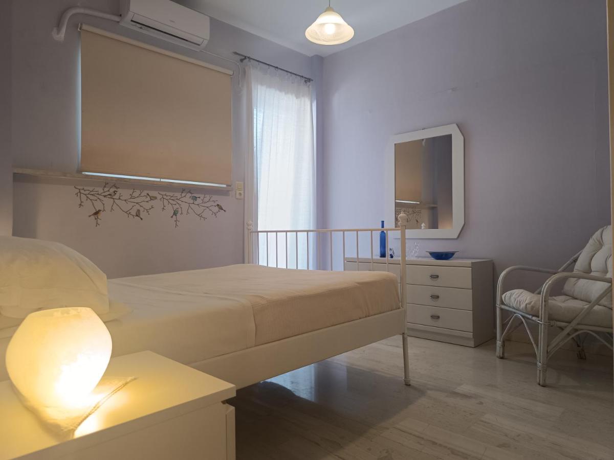 White metal bed with beige bedding sits at dog-friendly Eftihia Apartments by the Sea in Old Town Rethymnon.