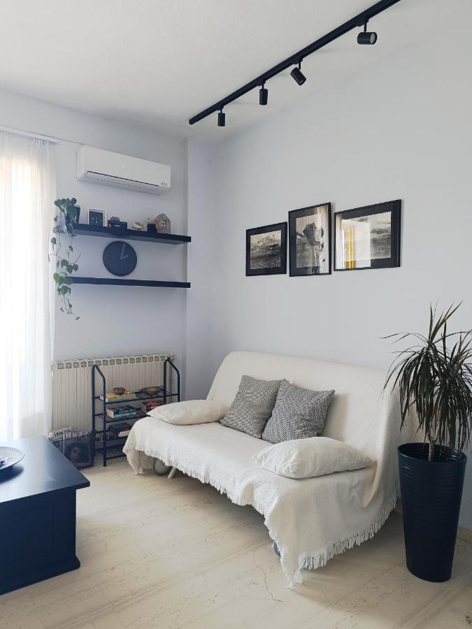 White sofa with gray pillows sits at dog-friendly Eftihia Apartments by the Sea in Old Town Rethymnon.