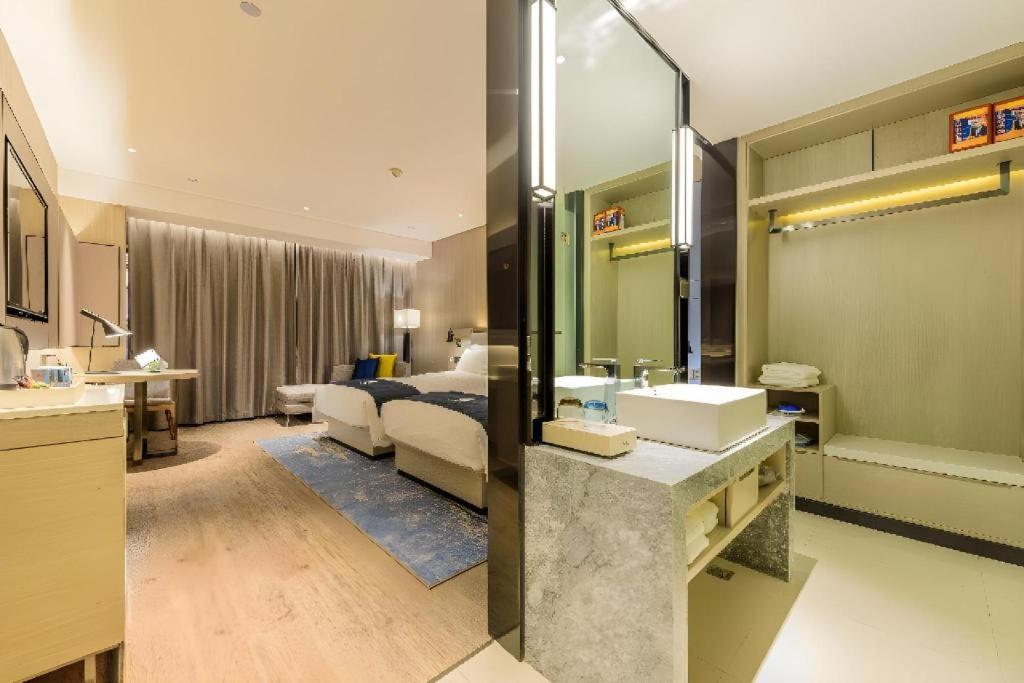 Two white beds with blue runners sit at dog-friendly Echarm Hotel Wuhan Plaza Wansongyuan in Wuhan.