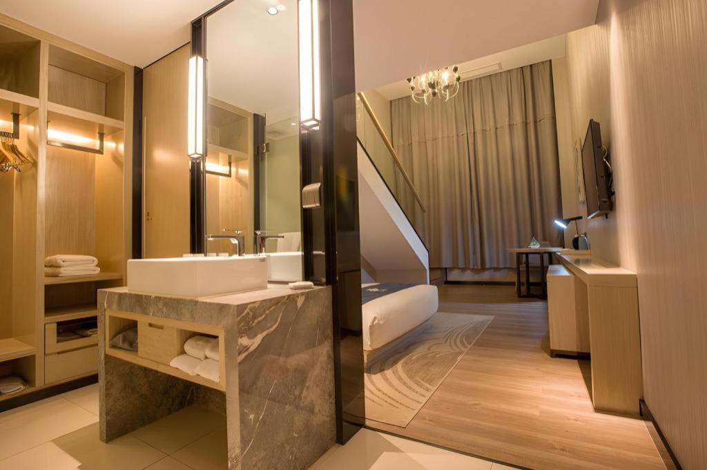 The beige and wood-accented hotel room sits at dog-friendly Echarm Hotel Wuhan Plaza Wansongyuan in Wuhan.
