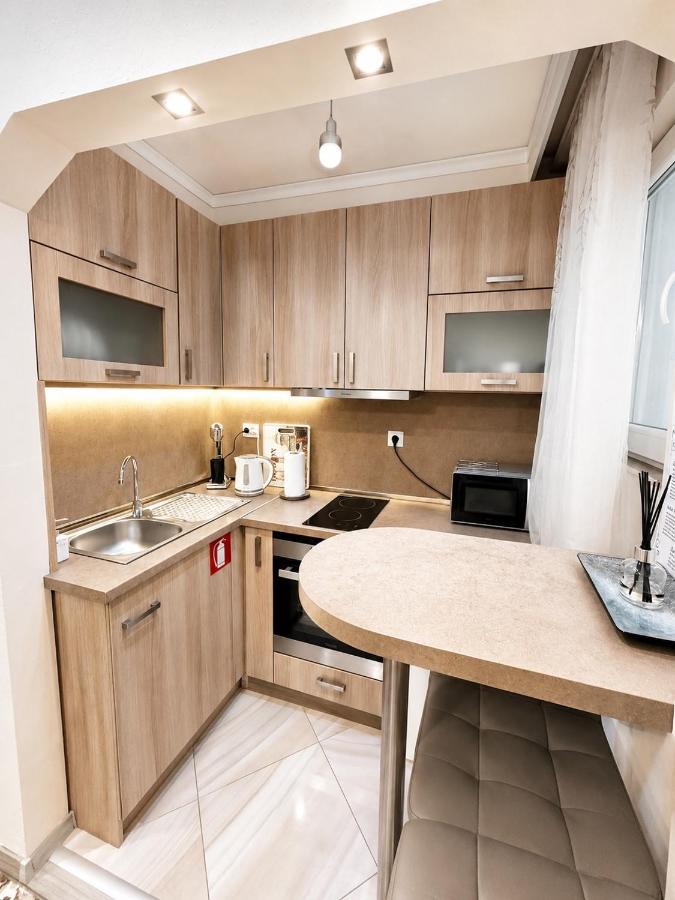 Light wood kitchenette with beige countertop sits at dog-friendly Emanuela Holidays With Private Parking in Kavala.