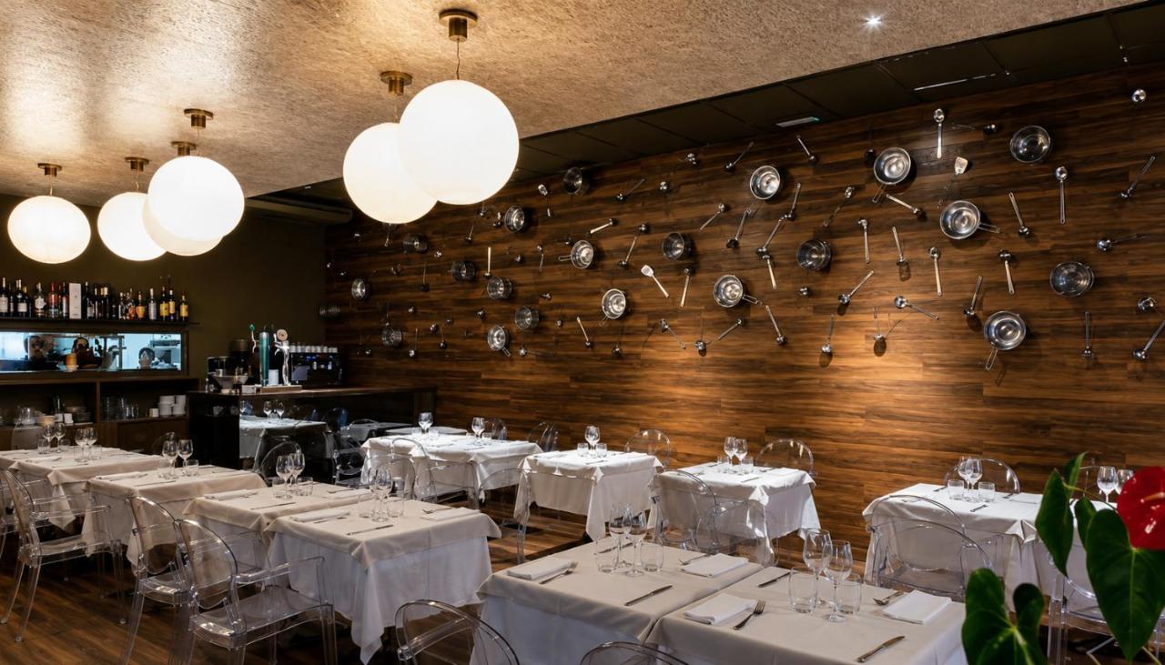 Clear acrylic chairs and white tablecloth tables are arranged at dog-friendly Hotel Roca Plana in L'Ampolla.