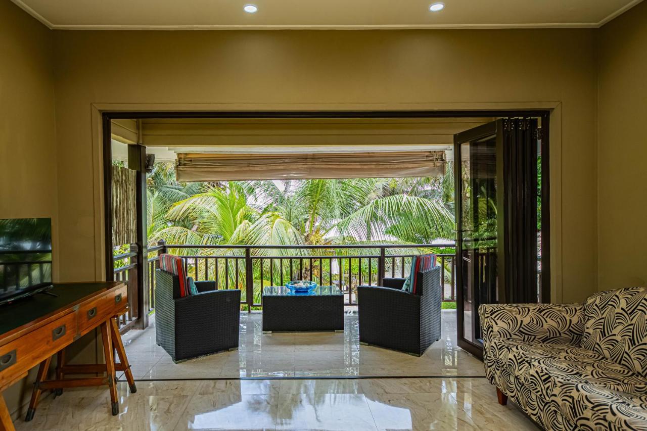 Two black wicker chairs with red-striped cushions face the balcony at dog-friendly Villas des Alizes in Praslin Island.
