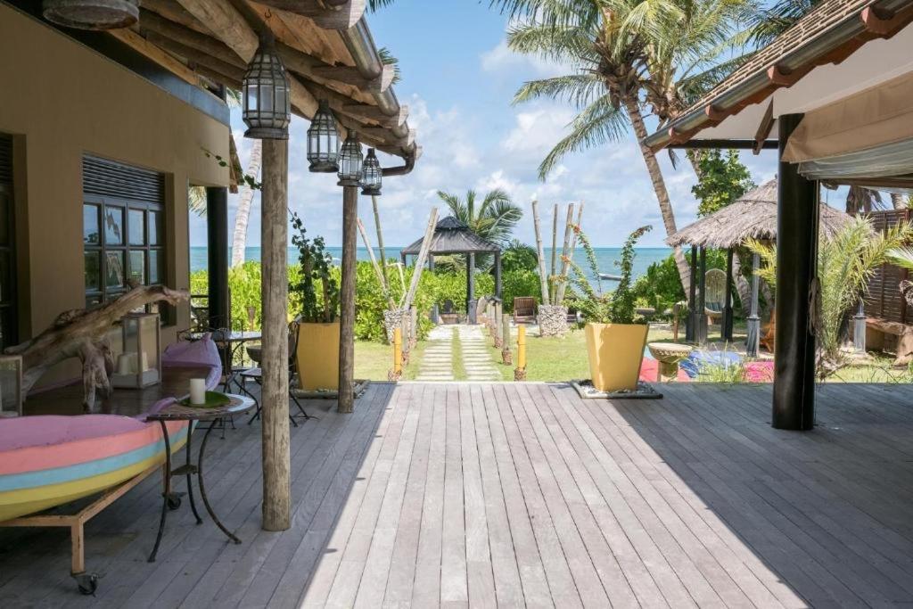 Yellow ceramic planter with green foliage stands on wooden deck at pet-friendly Villas des Alizes in Praslin Island.