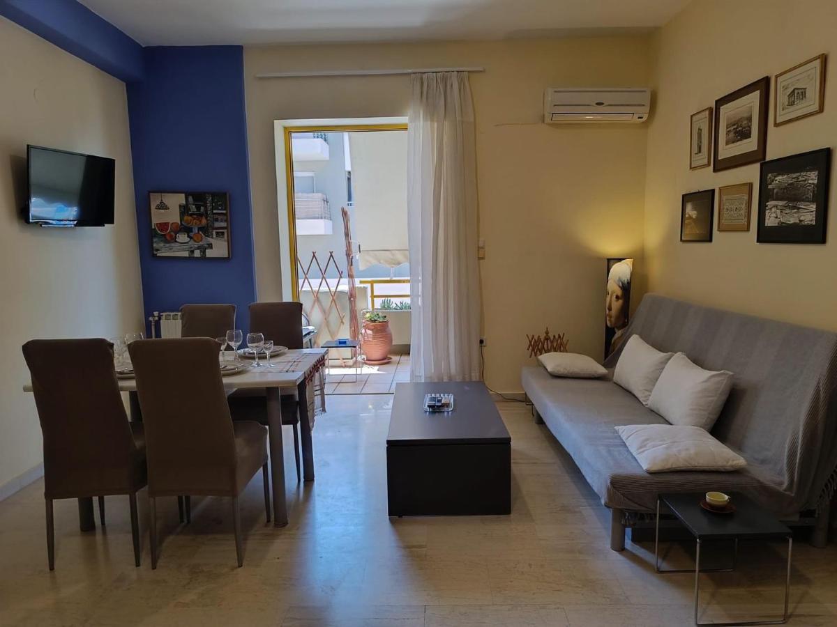 Gray sofa with white pillows sits against wall at pet-friendly Nova Sea & City Apartments in Old Town Rethymnon.