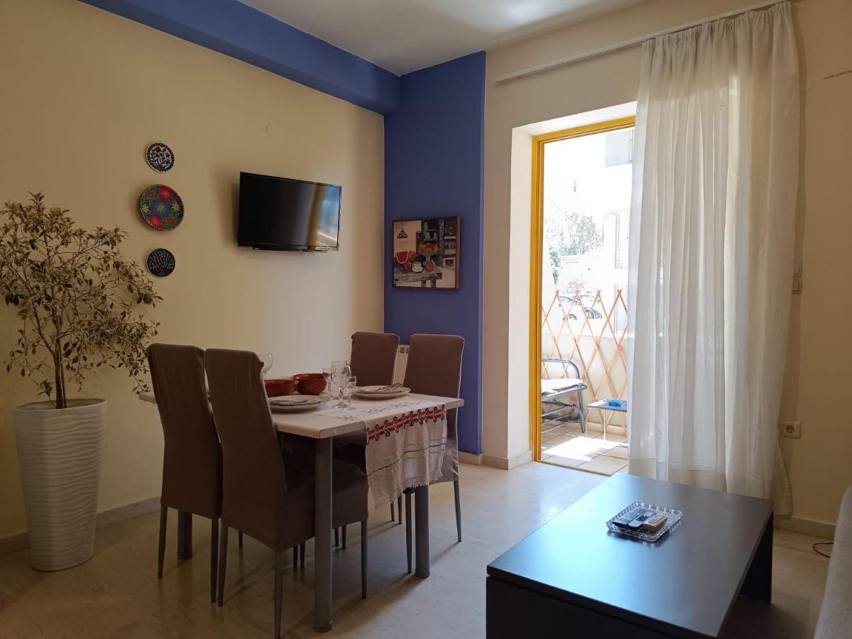 Four taupe upholstered dining chairs surround white table at dog-friendly Nova Sea & City Apartments in Old Town Rethymnon.