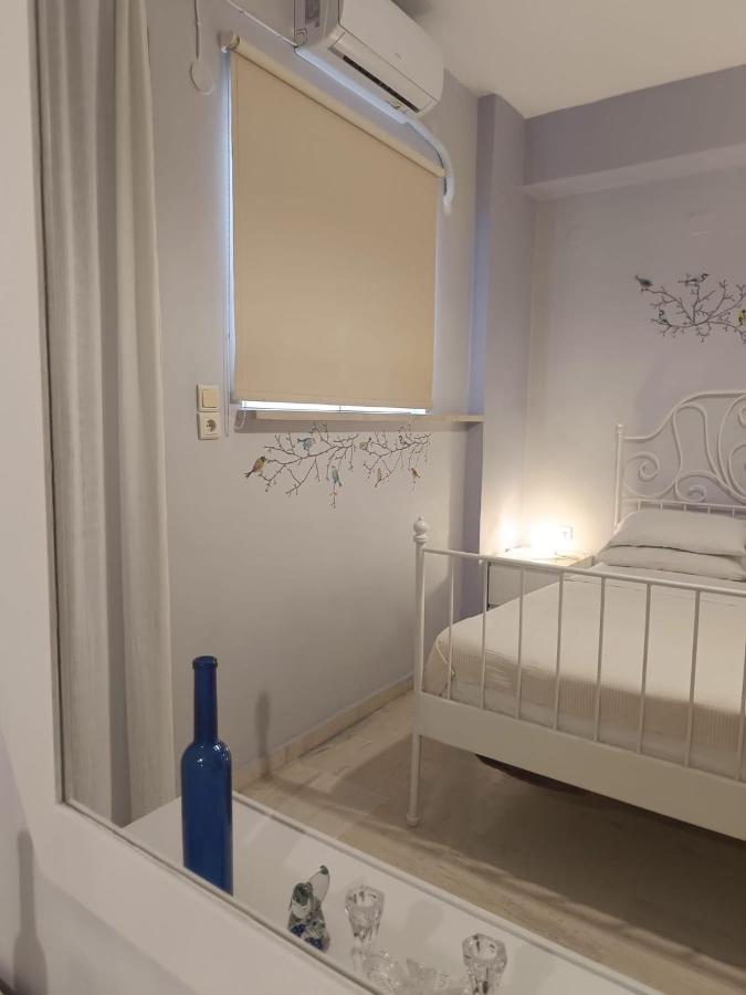 White wrought-iron bed with white linens stands at dog-friendly Nova Sea & City Apartments in Old Town Rethymnon.