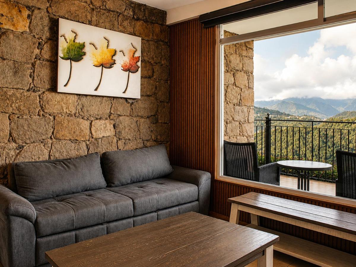 A gray tufted sofa sits at dog-friendly Vista Zacatlan Hotel in Zacatlán.