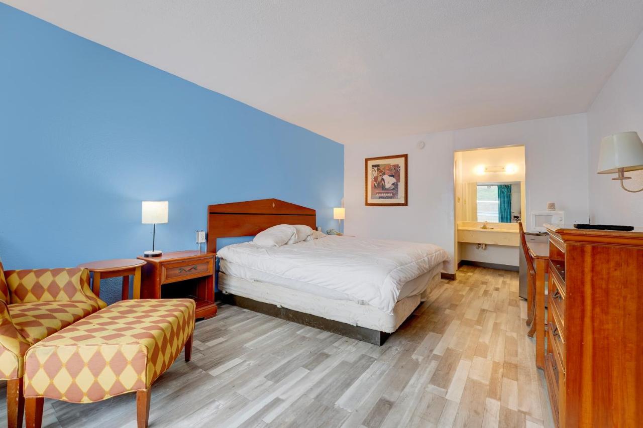 White bed with headboard sits on floor at dog-friendly Ole South Inn Jackson I 40 TN in Denmark, TN.