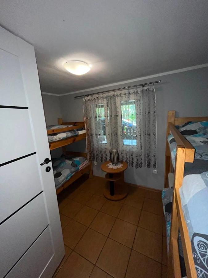 Wooden bunk beds with blue-gray patterned bedding stand at dog-friendly Gospodarstwo Agroturystyczne Na Mazurach in Jerutki.