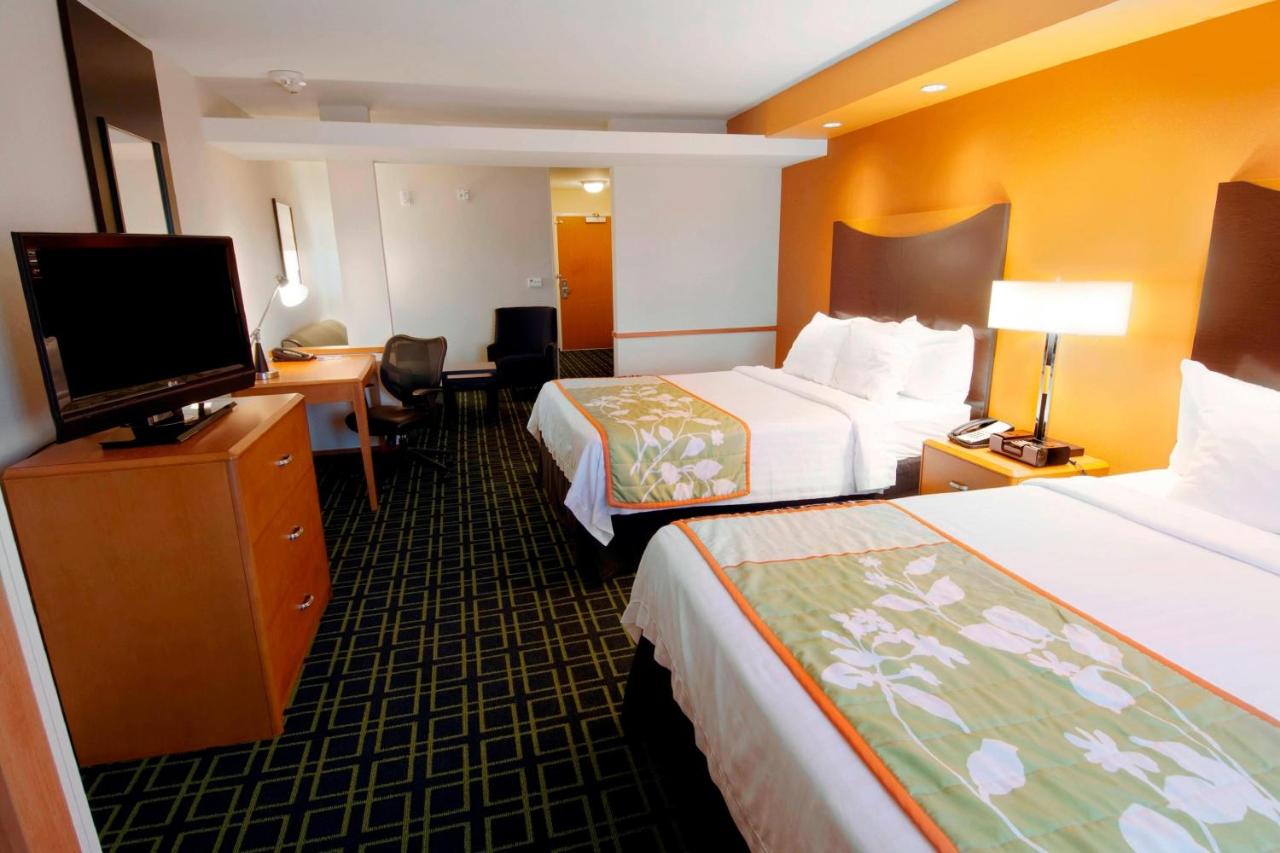 Two white beds with green runners are at dog-friendly Fairfield Inn & Suites Milledgeville in Milledgeville, GA.