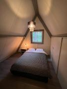 Dennenrust A-frame huisje middenin het bos.