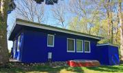 Blauer Bungalow am See mit Boot
