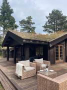 Norwegian Log Cabin Among Heather And Pine Trees