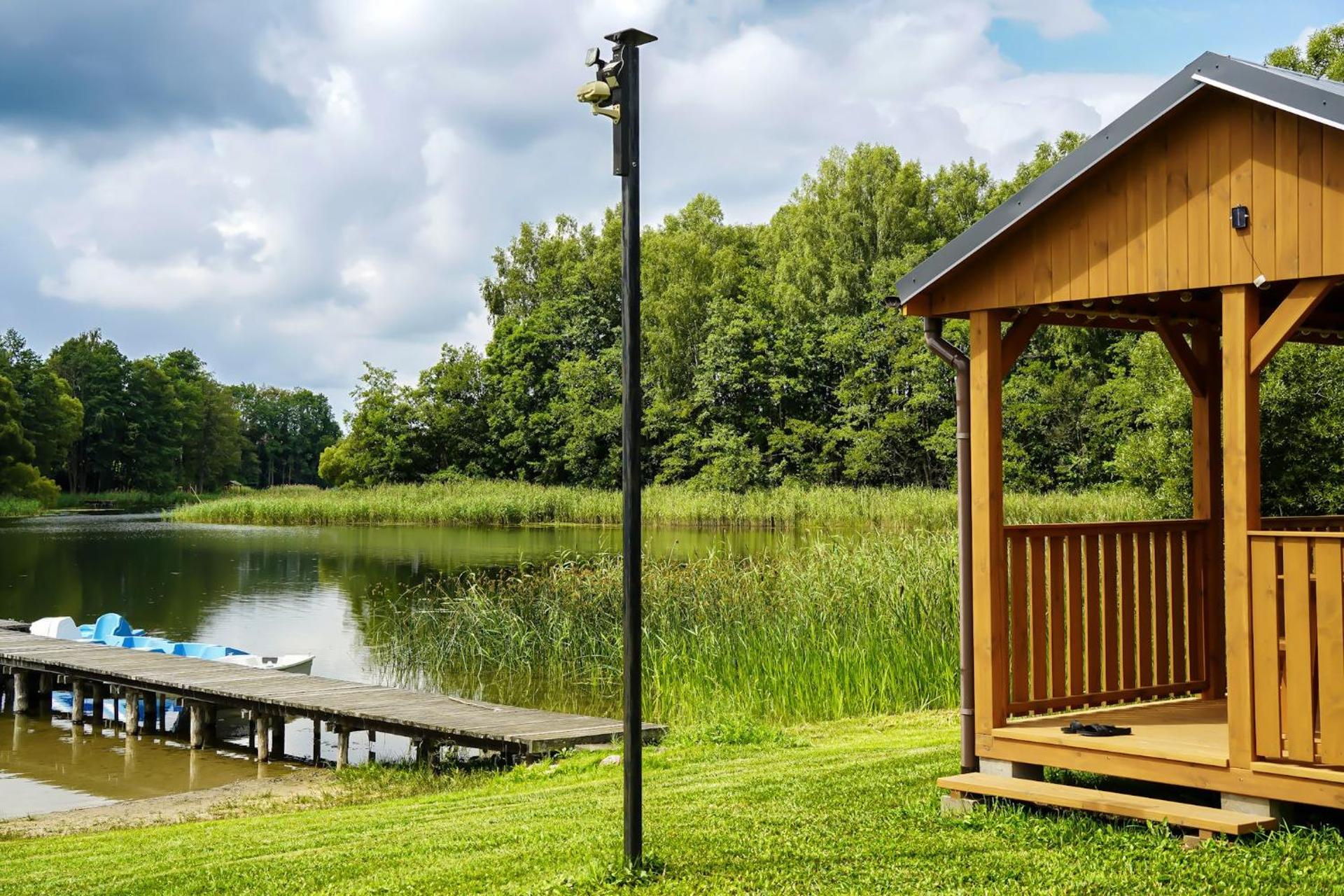 Domek z kominkiem nad jeziorem z jacuzzi ogrodowym