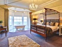 Habitación de lujo con bañera de hidromasaje y cama con dosel