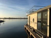 Modernes festliegendes Hausboot mit großzügiger Dachterrasse und Ruderboot - B&B Röbel