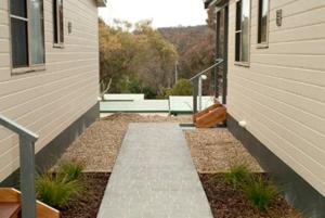 a walkway leading to a house with a porch, Alivio Tourist Park Canberra in Canberra