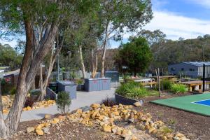 a park with a lot of trees and benches, Alivio Tourist Park Canberra in Canberra
