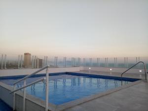 Prédio com piscina na cobertura frente ao mar, apartamento para até 6 pessoas e 3 crianças até 8 anos, churrasqueira na sacada, Wi-Fi grátis, NÃO oferecemos roupas de cama e banho, 1 vaga de garagem, na Praia Grande-Vila Mirim
