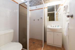 a bathroom with a toilet, sink and shower, Alivio Tourist Park Canberra in Canberra