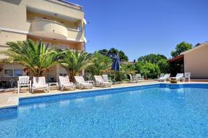 Zum Sandstrand sind es wenige Gehminuten - genießen Sie aber auch die Zeit am Pool