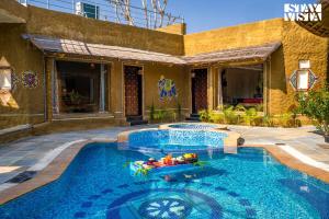 StayVistas Majestic Mud House - Rajasthani Architecture with Modern Amenities, Outdoor Pool, Adventure Activities, and Spa