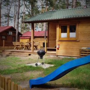 Jasnochówka Domek z widokiem na jezioro i placem zabaw oraz ogrodzeniem