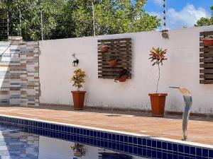 Apê pavimento superior com 3 quartos com ar condicionado, varanda e suite com vista para a piscina e internet privativa, a poucos metros da Praia de Taperapuã. Residencial Jardins de Taperapuã, condomínio com piscina, 2 vagas de garagem e área g