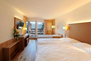 Family Room (2 Adults + 1 Child) with Balcony and Mountain View room in Hotel Helvetia Intergolf