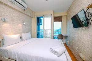 Minimalist Studio with Great City View at Tifolia Apartment By Travelio