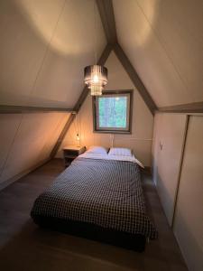 Dennenrust A-frame huisje middenin het bos.