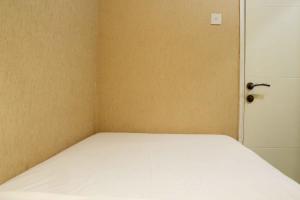 Minimalist and Warm 2BR Bassura City Apartment By Travelio