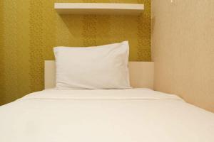 Minimalist and Warm 2BR Bassura City Apartment By Travelio