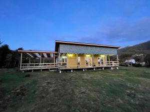 Cabaña con árboles nativos en su patio.