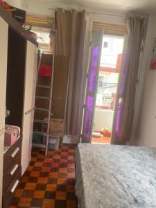 Quarto com sacada possui cama de casal, ventilador e guarda-roupa