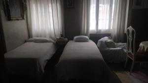 habitación de 2 camas con 2 ventanas al exterior y TV en casa compartida