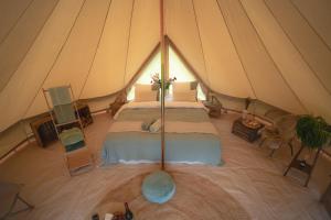 Boutique tent Pruum op een unieke plek in het groen met luxe bed
