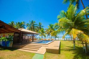 Casa completo com grande piscina sob coqueiros, pe na areia
