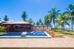 Casa completo com grande piscina sob coqueiros, pe na areia