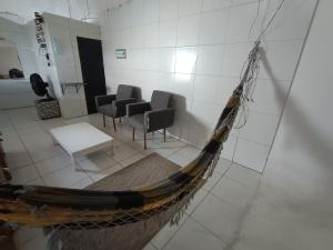 Espaço individual com sofá-cama rede mesa de jantar poltronas Ar Banheiro compartilhado