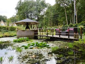 A detached bungalow with outdoor fireplace, covered terrace and pond in a forest plot