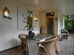 A detached bungalow with outdoor fireplace, covered terrace and pond in a forest plot