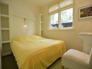 A detached bungalow with outdoor fireplace, covered terrace and pond in a forest plot