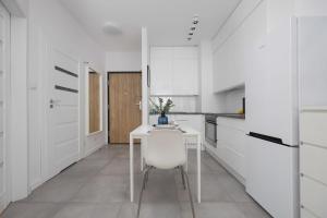 Bright Grey Apartment in Warsaw with Balcony by Noclegi Renters