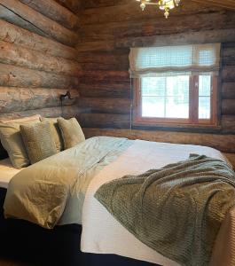 Kuonti-Ruka, kelohirsimökki järven rannalla