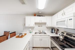 Updated condo with balcony central AC pools hot tub grills & beach access