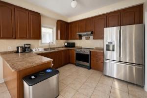 Private Queen Bedroom with Walk-In Closet, TV & Mini Fridge in Brampton Shared Home - 3 Baths, Full Kitchen, WiFi, Laundry & Deck - Near GO Station, Ideal for Work & Study!