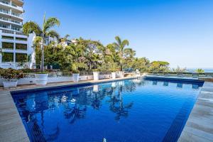 Modern hillside suite with balcony, city view, pools, gym & full kitchen